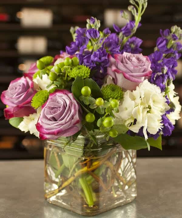 A fashionable design of garden fresh flowers in stylish purple, lavender, and lime green hues. Featured blooms include roses, stock, hypericum, carnations, or similar favorites for a variety of shapes and textures. Select your variation