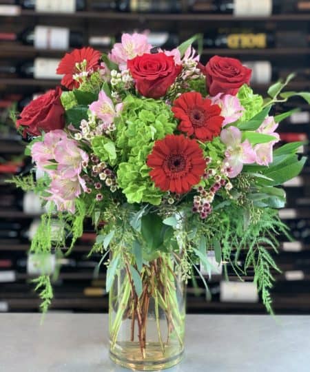 LOVE Is sure to to be In The Air when you send this beautiful and lush Valentines Day vase arrangement. Overflowing with Plumosa, Eucalyptus, Salal, Red Ecuadorian Roses, Pink Alstromeria Blossoms, Green Shamrock Hydrangea, Red Miniature Gerbera Daisies, and Hybrid Wax Flower, this Valentine Gift Is sure guarantee LOVE Is In The Air
