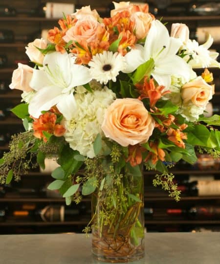 STUNNING! This calm fall arrangement is sure to bring a slice of serenity to your home. white hydrangea, seeded eucalyptus, peach Ecuadorian roses, white oriental Lilies, white Gerbera daisies, orange Alstromeria, and more in shades of peach and orange mingle together to create a beautiful Autumn gift. 